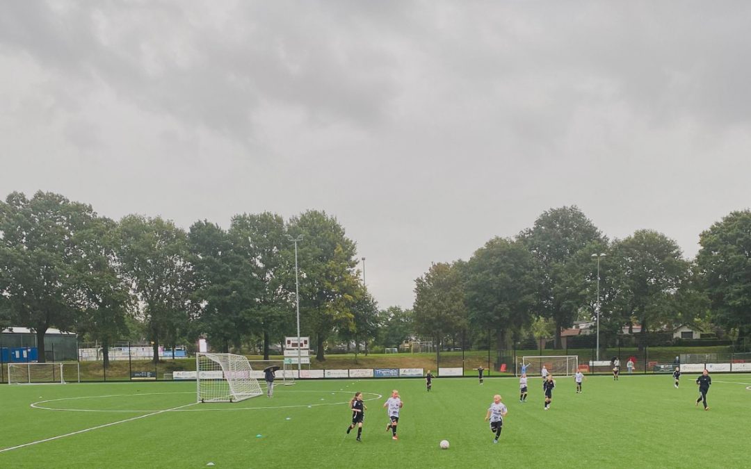 Teamspirit in een regenachtige wedstrijd.